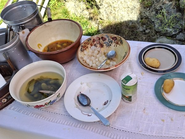 Besteck, Cornichons, Curry-Zucchetti, Silberzwiebeln, frische Zwiebeln (offenbar sehr beliebt!), Kartoffeln warten auf den Käse. - © René Buss